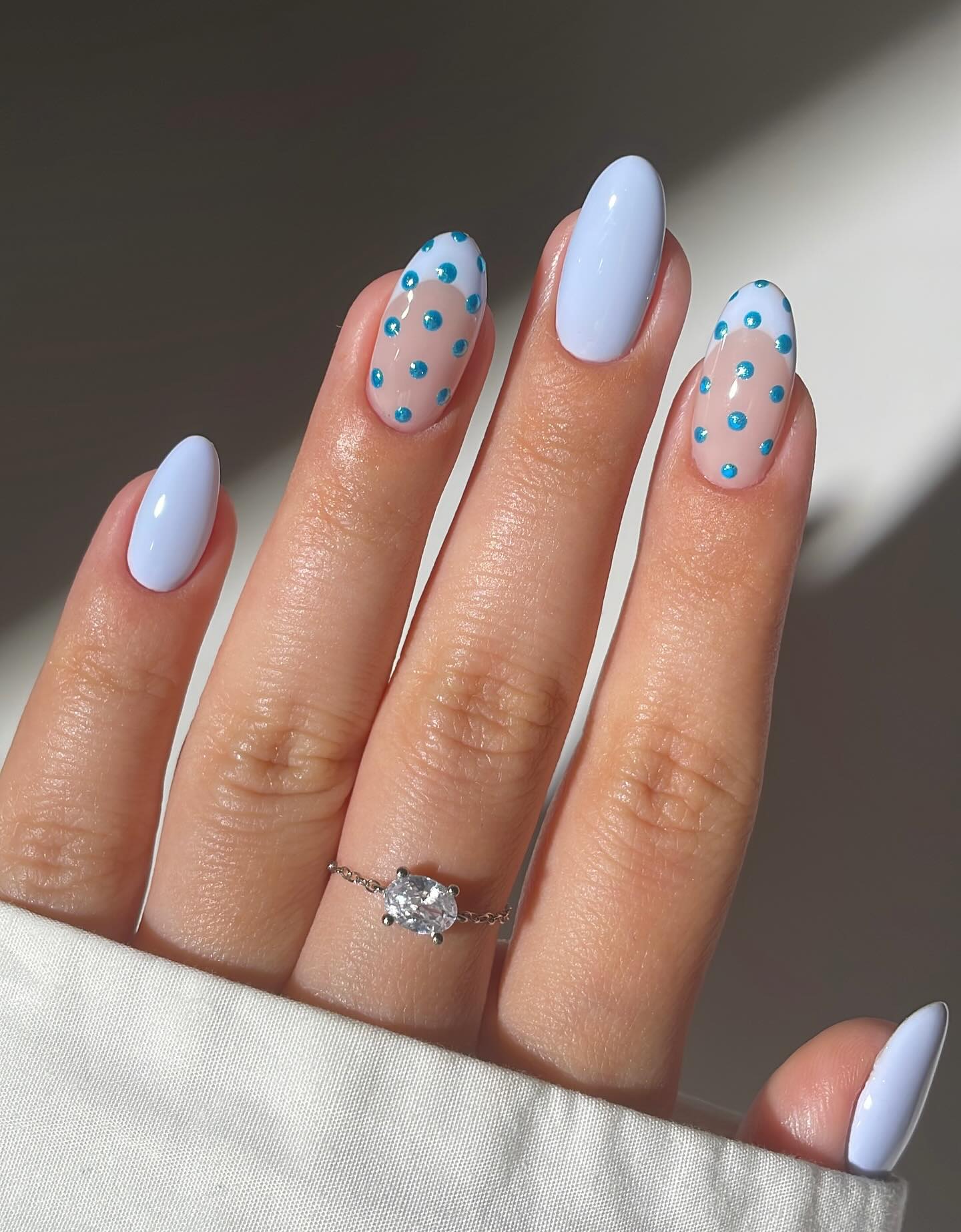 Light blue nails with teal polka dots